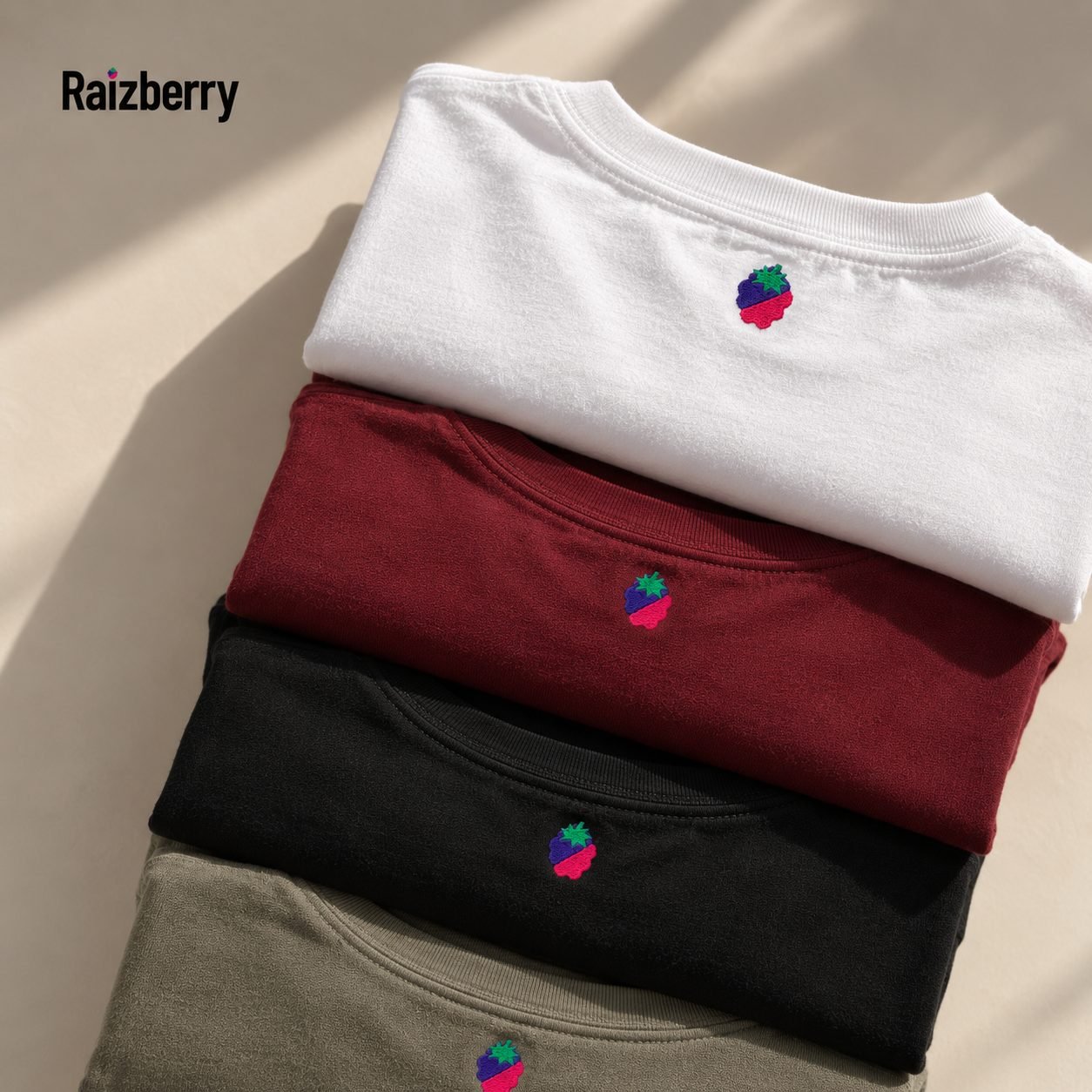 Quatre t-shirts Raizberry pliés, avec la framboise brodée sous le col.